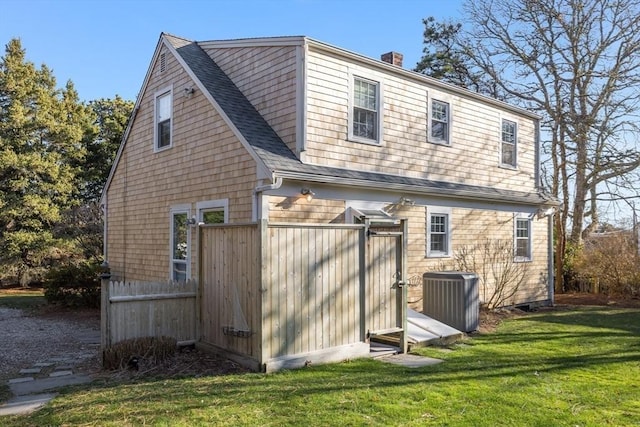 rear view of property with a lawn and central AC unit