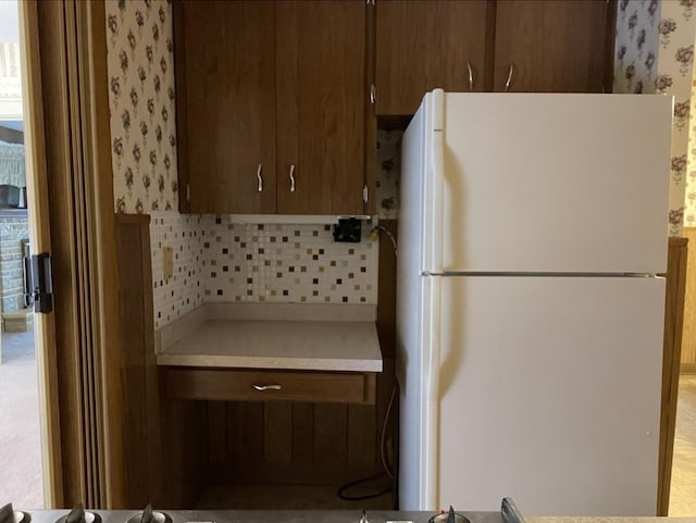 kitchen with tasteful backsplash and white fridge