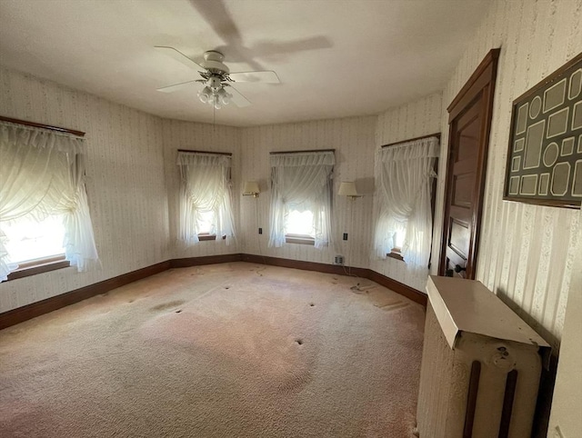 empty room featuring ceiling fan, carpet floors, and radiator heating unit