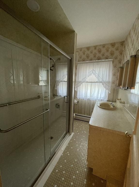 bathroom featuring baseboard heating, vanity, tile patterned flooring, and a shower with shower door