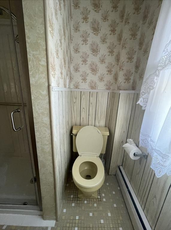 bathroom featuring a baseboard heating unit, a shower with door, and tile patterned flooring