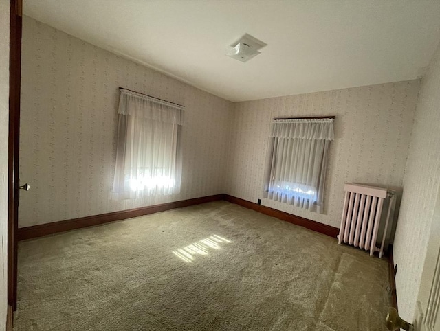 spare room with carpet and radiator heating unit