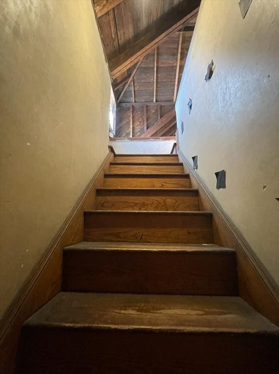 stairway with vaulted ceiling, wood ceiling, and wooden walls