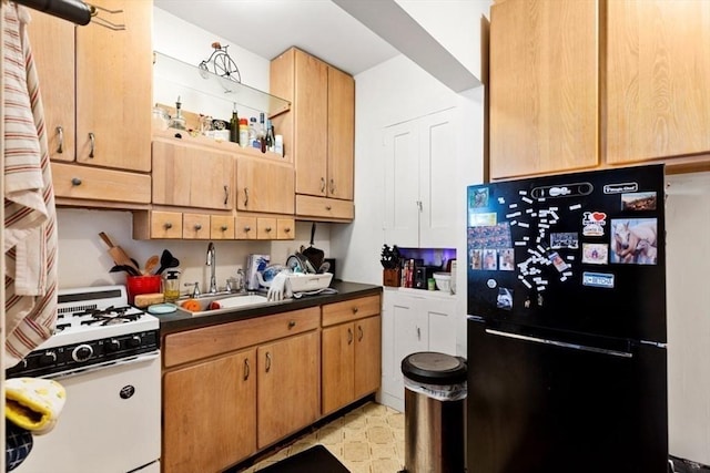 126 W Wyoming Ave, Melrose, MA 02176 - kitchen featuring freestanding refrigerator, white range with gas stovetop, dark countertops, a sink, and refrigerator