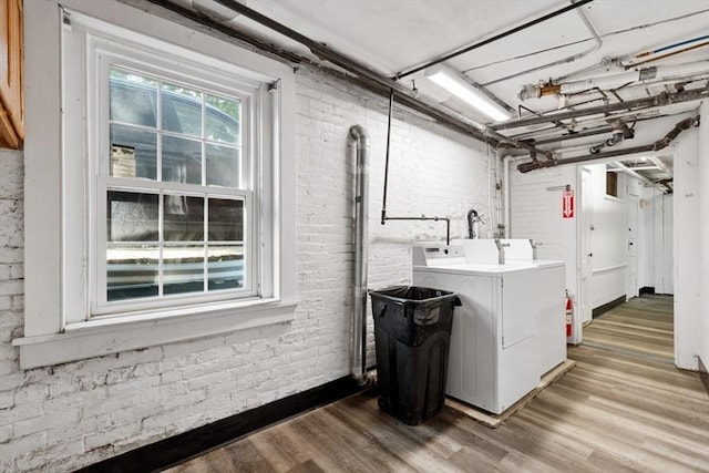 126 W Wyoming Ave, Melrose, MA 02176 - clothes washing area with brick wall, washer and dryer, and light wood-style flooring