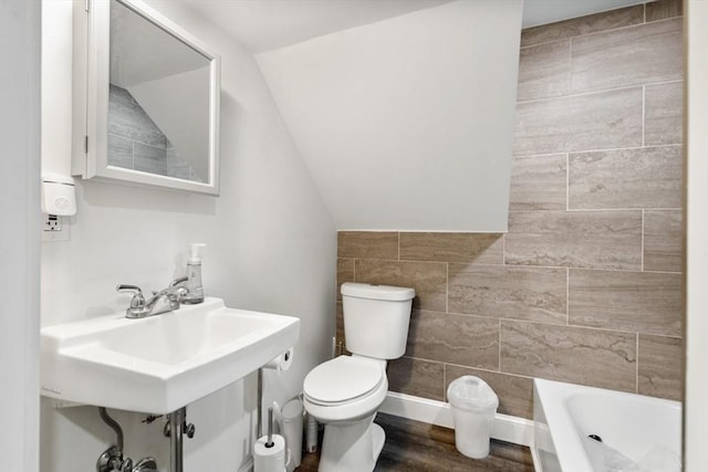 126 W Wyoming Ave, Melrose, MA 02176 - full bath featuring toilet, lofted ceiling, tile walls, and a sink