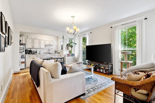 126 W Wyoming Ave, Melrose, MA 02176 - living area featuring a chandelier, light wood finished floors, and baseboards