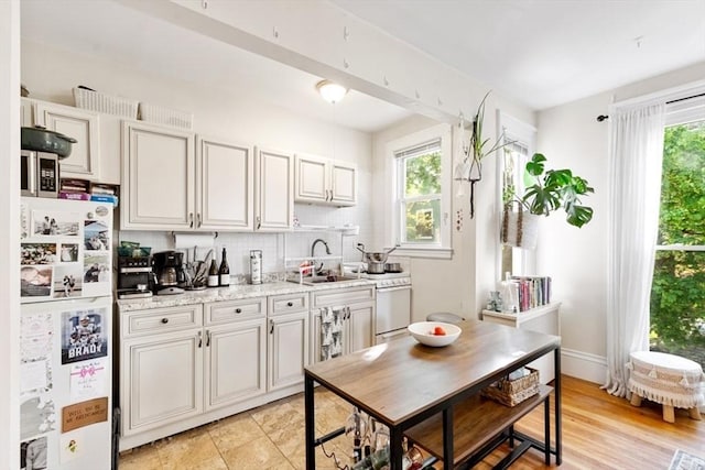 126 W Wyoming Ave, Melrose, MA 02176 - kitchen featuring white appliances, a sink, healthy amount of natural light, and tasteful backsplash