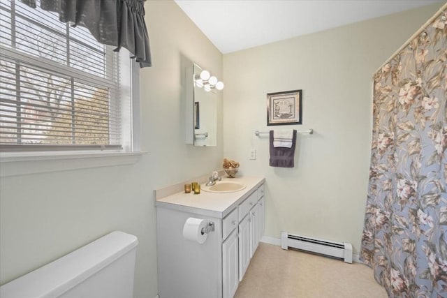 bathroom with vanity, baseboard heating, and toilet