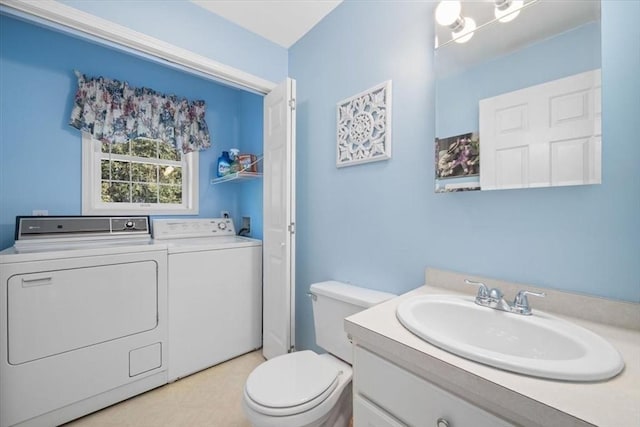 bathroom with vanity, independent washer and dryer, and toilet