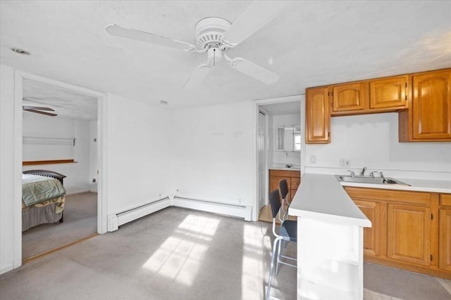 kitchen featuring ceiling fan, a baseboard radiator, and sink