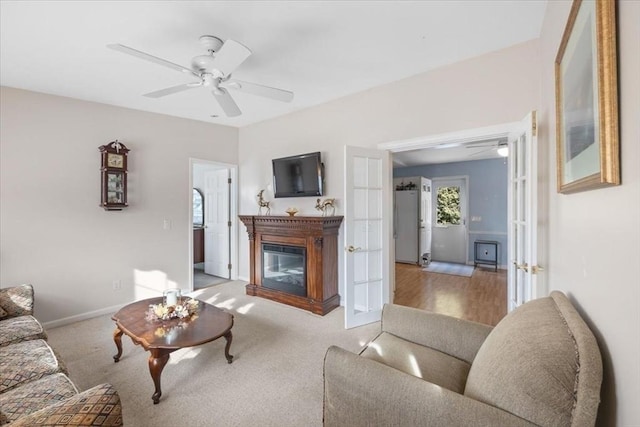 carpeted living room with french doors and ceiling fan