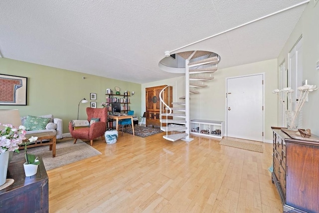 61 Broad Reach Unit T62B, Weymouth, MA 02191 - sitting room with stairs, light wood-style floors, a textured ceiling, and baseboards