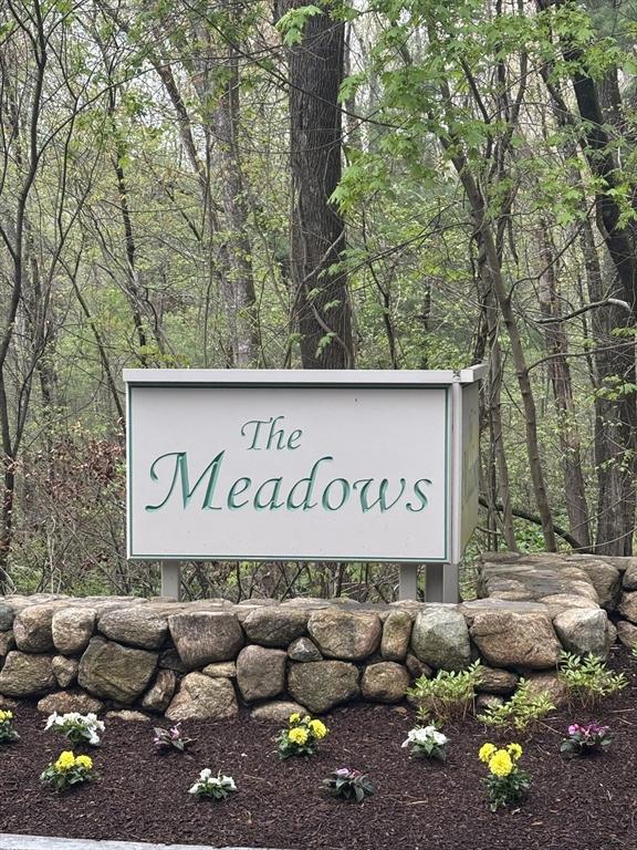community sign with a wooded view