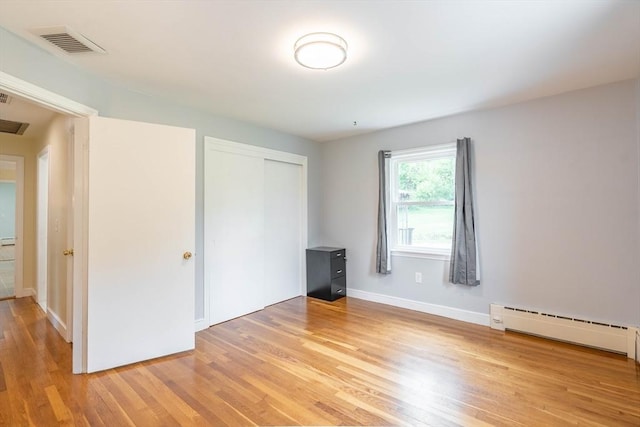 19 Zabelle Ave, Auburn, MA 01501 - unfurnished bedroom featuring light wood-style flooring, a closet, baseboards, and a baseboard heating unit