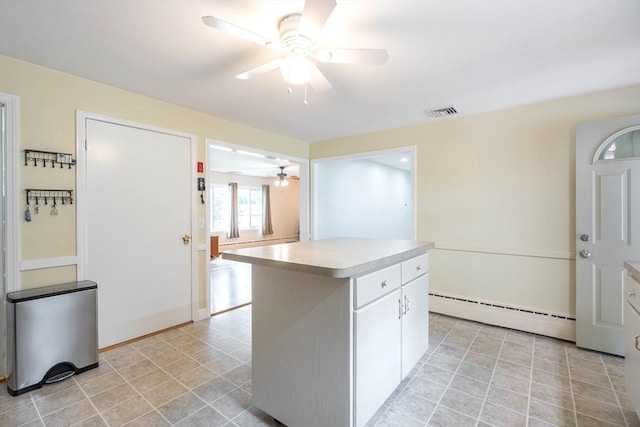 19 Zabelle Ave, Auburn, MA 01501 - kitchen featuring a ceiling fan, a baseboard heating unit, light countertops, a kitchen island, and white cabinets
