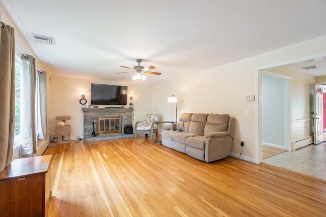 19 Zabelle Ave, Auburn, MA 01501 - living room featuring light wood-style flooring, a ceiling fan, baseboard heating, and a fireplace