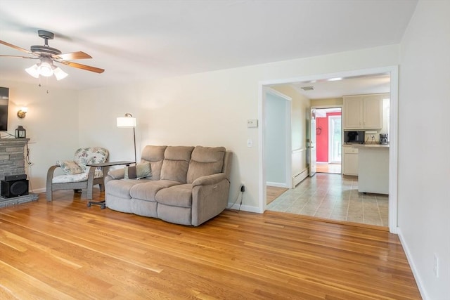 19 Zabelle Ave, Auburn, MA 01501 - living room featuring light wood-style floors, a ceiling fan, baseboards, and a stone fireplace