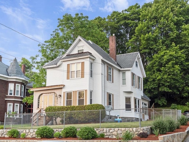 743 Bridge St, Lowell, MA 01850 - view of front of property featuring a chimney and a shingled roof