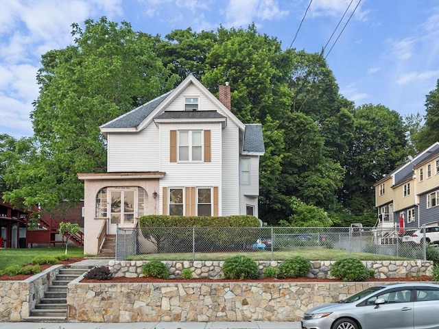 743 Bridge St, Lowell, MA 01850 - view of front of house featuring a chimney, a fenced front yard, stairs, and roof with shingles