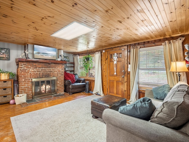 living room with hardwood / wood-style flooring, wooden ceiling, a brick fireplace, and plenty of natural light