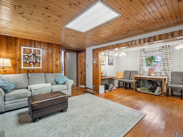 living room featuring crown molding, hardwood / wood-style flooring, wooden ceiling, and wood walls