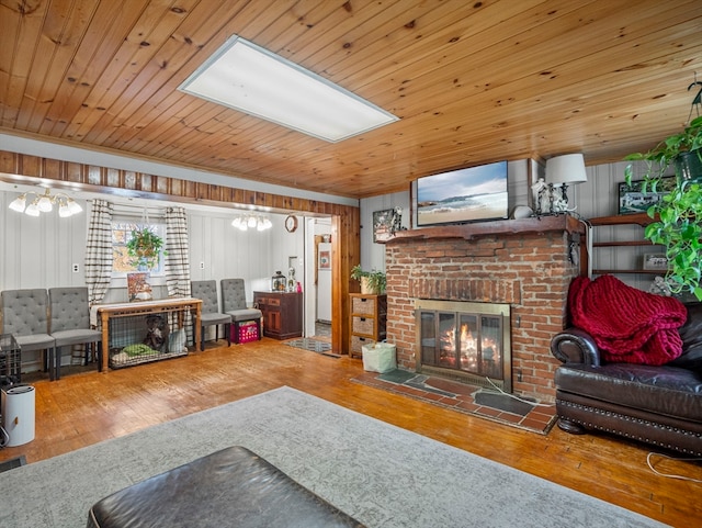 living room with hardwood / wood-style floors, a fireplace, wooden ceiling, and wooden walls