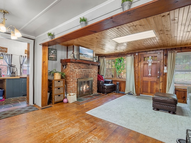 living room featuring a wealth of natural light, wooden walls, a fireplace, and hardwood / wood-style flooring