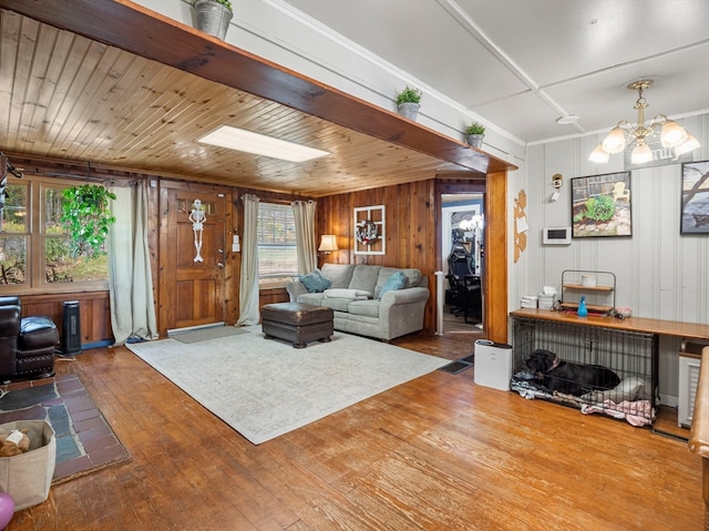 living room with wood ceiling, hardwood / wood-style floors, a chandelier, and wooden walls