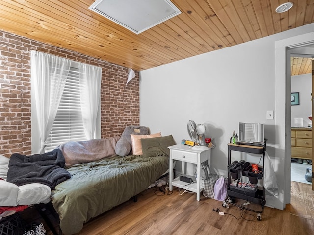 bedroom featuring wood ceiling, hardwood / wood-style flooring, and brick wall