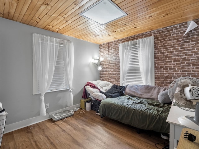 bedroom featuring brick wall, wood-type flooring, a skylight, and wooden ceiling