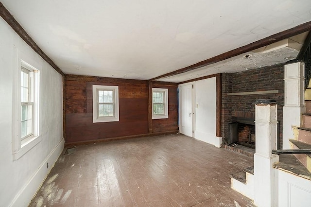 171 Hobart St, Danvers, MA 01923 - unfurnished living room with a fireplace, hardwood / wood-style floors, wooden walls, and baseboards