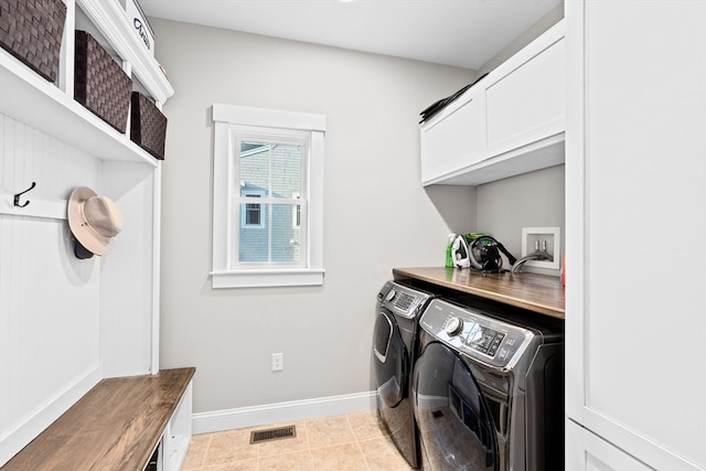 laundry area with cabinets, light tile patterned flooring, and separate washer and dryer