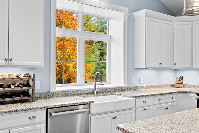 kitchen featuring white cabinetry, vaulted ceiling, stainless steel dishwasher, and sink