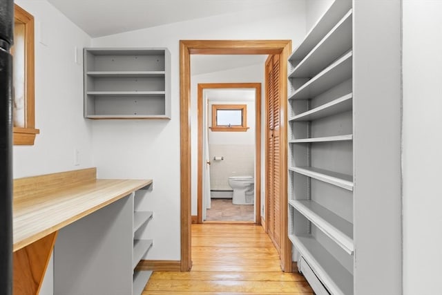 spacious closet with a baseboard heating unit and light wood-type flooring