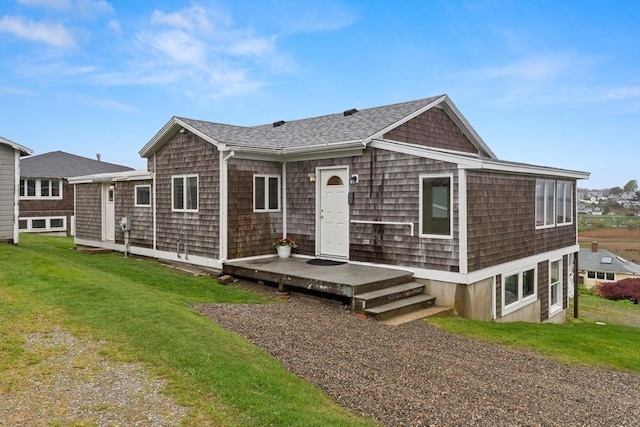 back of property featuring roof with shingles and a lawn