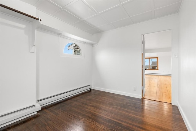 basement with a baseboard heating unit, hardwood / wood-style floors, and a baseboard radiator