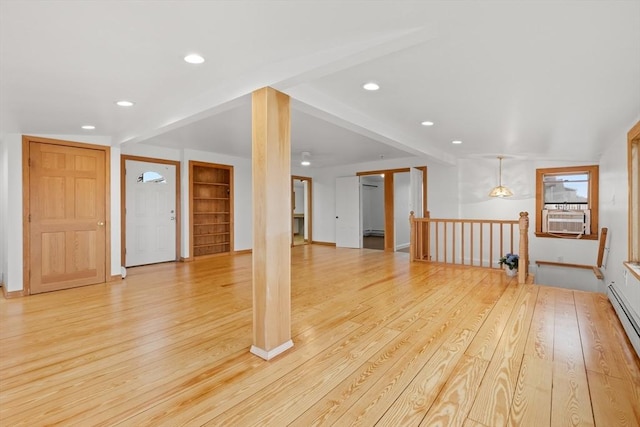 unfurnished living room featuring light wood-style flooring, cooling unit, baseboard heating, built in shelves, and recessed lighting