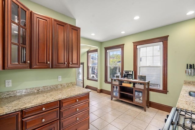 kitchen with baseboards, recessed lighting, and glass insert cabinets