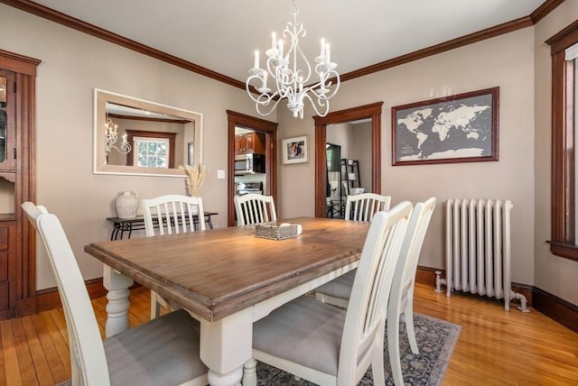 dining room with an inviting chandelier, radiator, and light wood finished floors
