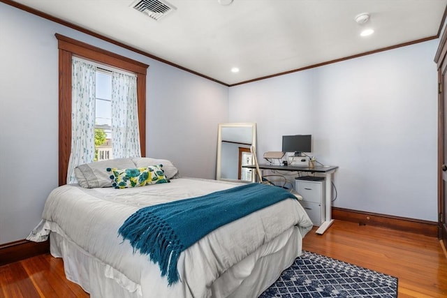 bedroom with recessed lighting, baseboards, wood finished floors, visible vents, and ornamental molding