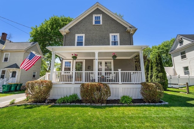 traditional style home featuring a porch and a front yard