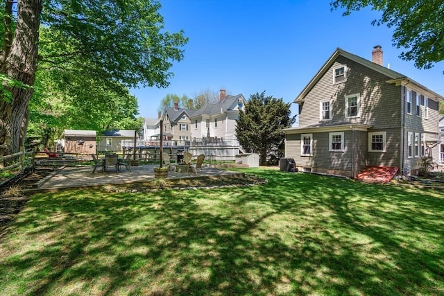 view of yard featuring an outdoor structure, a wooden deck, and a shed