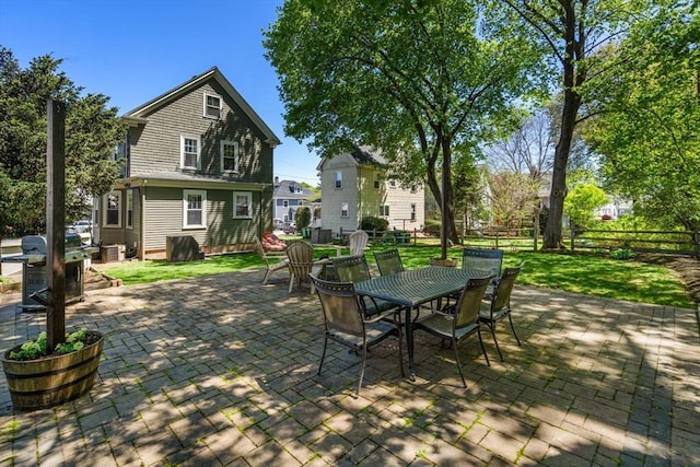view of patio with outdoor dining area, fence, and a grill