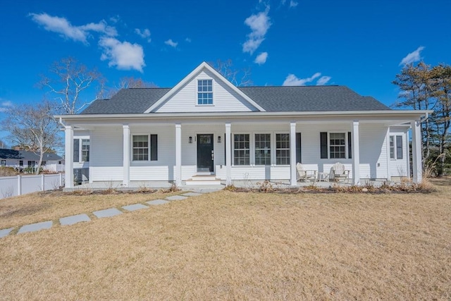 view of front of property featuring a porch, fence, and a front lawn