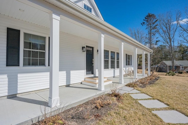 property entrance featuring a porch and a lawn