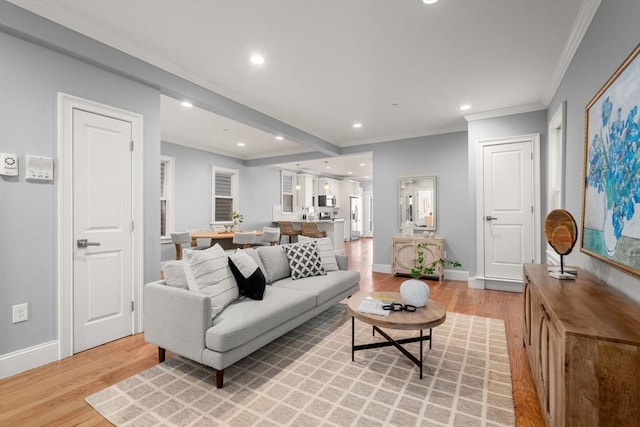 living area featuring crown molding, recessed lighting, baseboards, and light wood-type flooring
