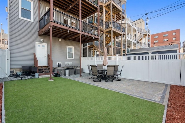 rear view of property with a lawn, fence, a patio area, and entry steps