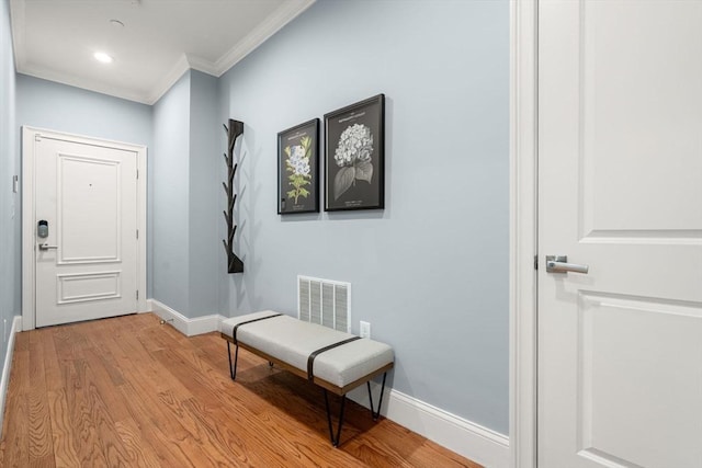 doorway to outside with recessed lighting, baseboards, light wood-type flooring, visible vents, and ornamental molding