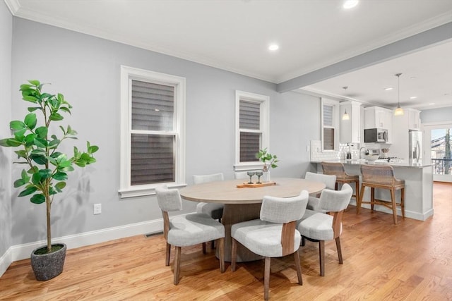 dining room with light wood-style floors, baseboards, crown molding, and recessed lighting
